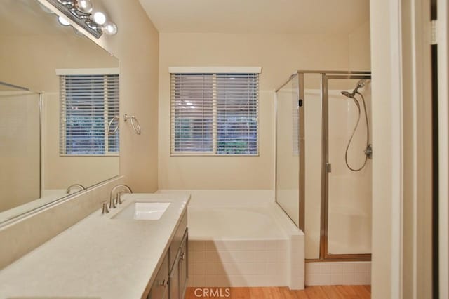 bathroom featuring shower with separate bathtub and vanity