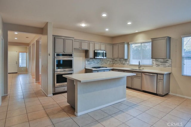 kitchen featuring sink, a wealth of natural light, stainless steel appliances, and a kitchen island