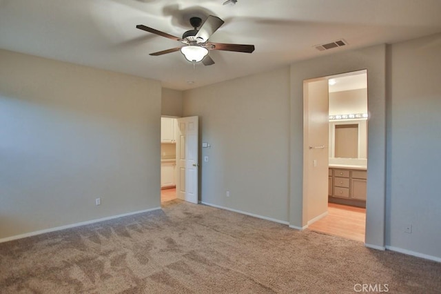 unfurnished bedroom with ensuite bathroom, ceiling fan, and light carpet