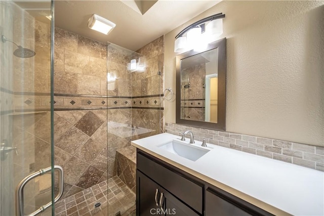 bathroom with backsplash, walk in shower, and vanity