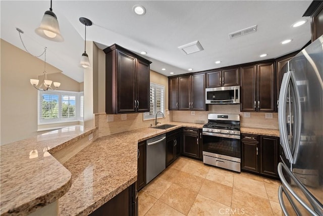 kitchen featuring decorative light fixtures, lofted ceiling, a notable chandelier, sink, and appliances with stainless steel finishes