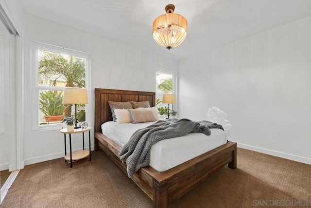 bedroom with a chandelier and dark colored carpet