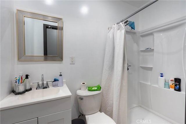 bathroom featuring toilet, vanity, and a shower with curtain