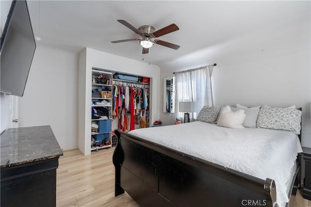 bedroom with a closet, light hardwood / wood-style floors, and ceiling fan