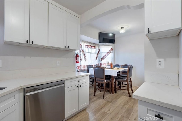 kitchen featuring white cabinetry, stainless steel dishwasher, light hardwood / wood-style flooring, and beamed ceiling