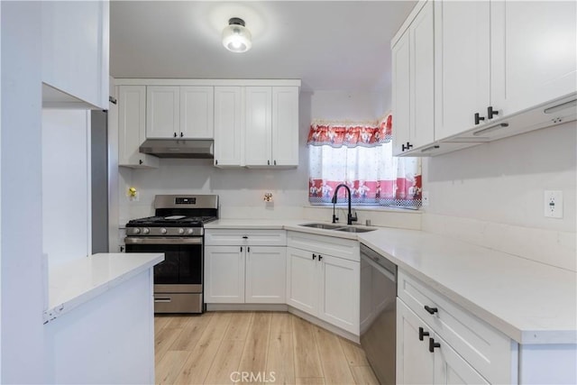 kitchen featuring white cabinets, sink, stainless steel appliances, and light hardwood / wood-style flooring