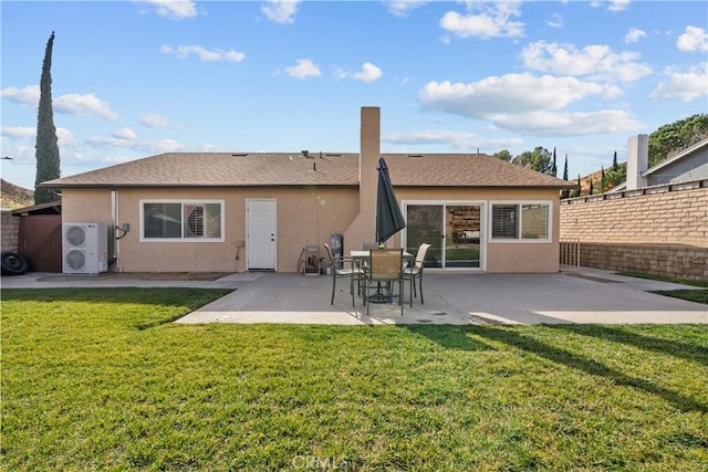 rear view of house with a lawn, ac unit, and a patio