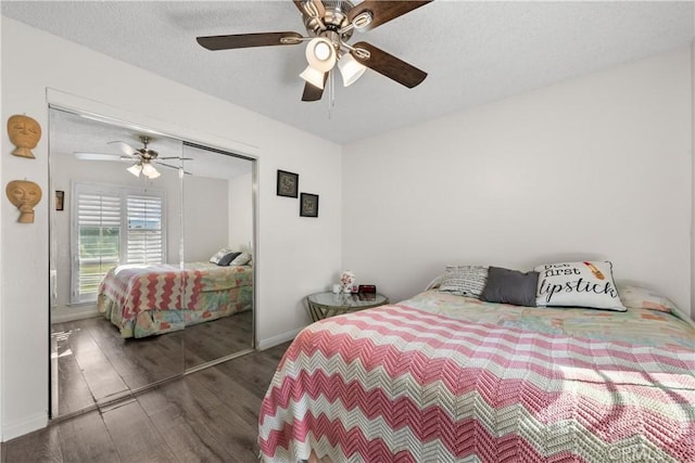 bedroom featuring dark wood-type flooring, a closet, a textured ceiling, and ceiling fan