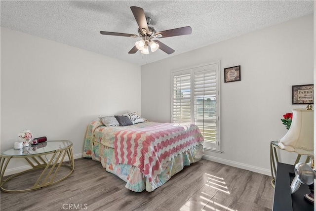 bedroom featuring a textured ceiling, ceiling fan, and wood-type flooring