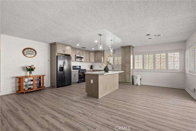 kitchen featuring light hardwood / wood-style floors, appliances with stainless steel finishes, a textured ceiling, a kitchen island, and pendant lighting