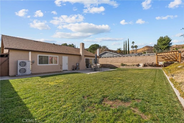 rear view of property with ac unit, a yard, and a patio