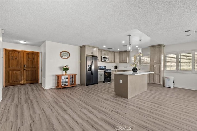 kitchen with decorative light fixtures, a center island, light hardwood / wood-style flooring, a textured ceiling, and stainless steel appliances