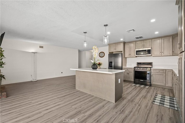 kitchen with stainless steel appliances, light wood-type flooring, a textured ceiling, pendant lighting, and a center island