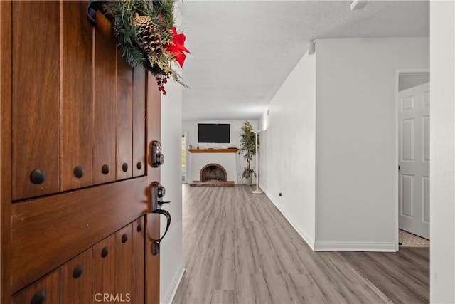 entrance foyer with a textured ceiling and light hardwood / wood-style flooring