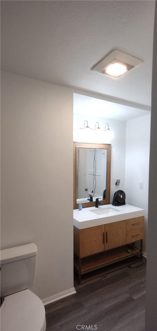 bathroom featuring hardwood / wood-style flooring, vanity, and toilet