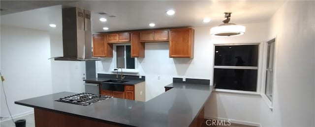 kitchen featuring sink, decorative light fixtures, appliances with stainless steel finishes, kitchen peninsula, and island exhaust hood