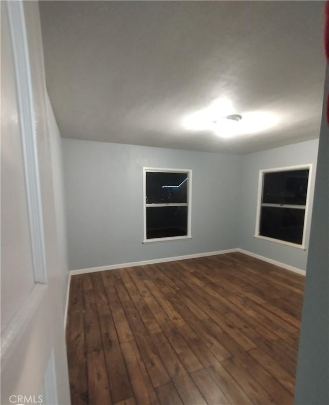 spare room featuring dark wood-type flooring