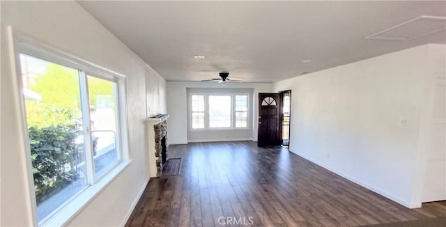 unfurnished living room featuring plenty of natural light, dark hardwood / wood-style floors, and ceiling fan