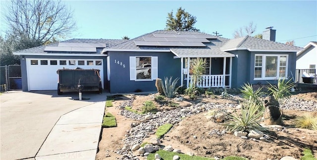 view of front facade with a porch, a garage, and solar panels