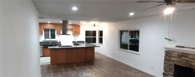 kitchen with island exhaust hood, gas stovetop, dark hardwood / wood-style flooring, ceiling fan, and a fireplace