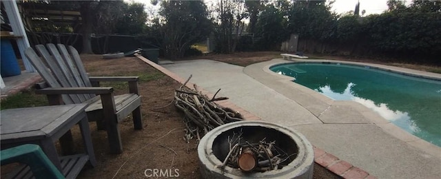 view of swimming pool featuring a diving board and a fire pit