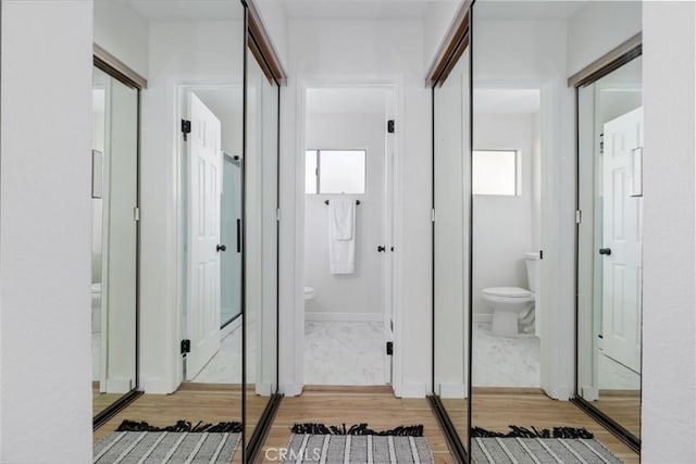 corridor with hardwood / wood-style flooring