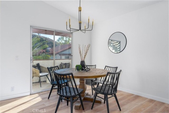 dining area with light wood-type flooring and a chandelier