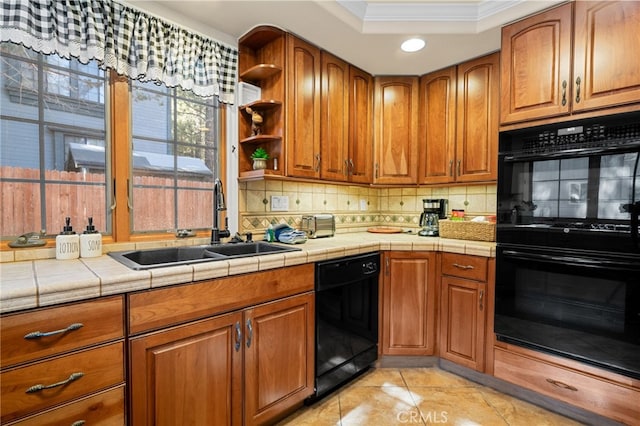 kitchen featuring tile counters, backsplash, ornamental molding, black appliances, and sink