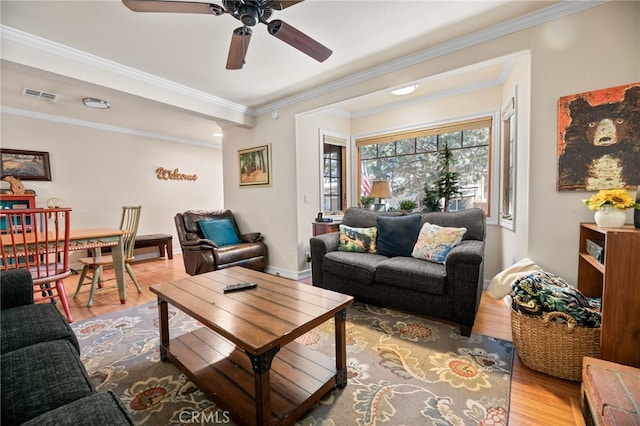 living room featuring ceiling fan, crown molding, and light hardwood / wood-style flooring