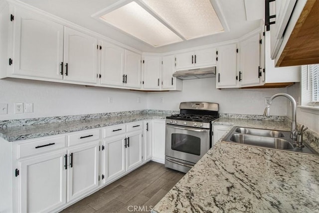 kitchen with gas range, sink, and white cabinets