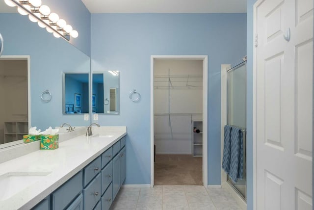 bathroom featuring walk in shower, vanity, and tile patterned floors