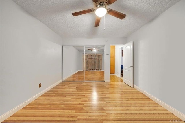 unfurnished room with ceiling fan, light hardwood / wood-style flooring, and a textured ceiling