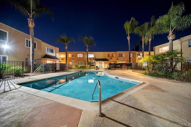 pool at twilight with a patio area