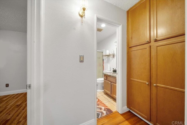 bathroom with vanity, toilet, hardwood / wood-style floors, and a textured ceiling