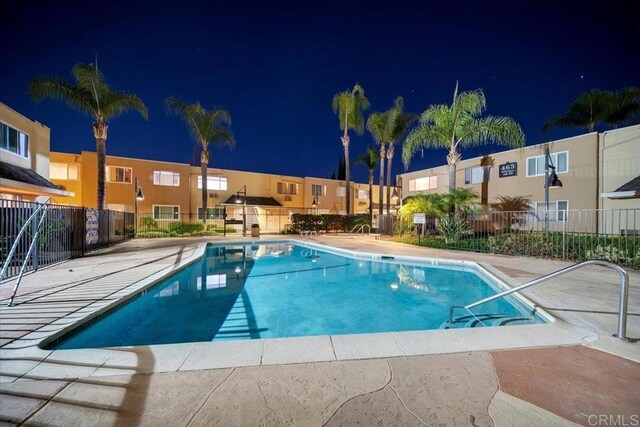 pool at twilight featuring a patio area