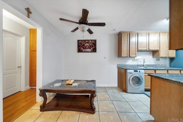 laundry room with washer / dryer, sink, light tile patterned floors, ceiling fan, and a textured ceiling