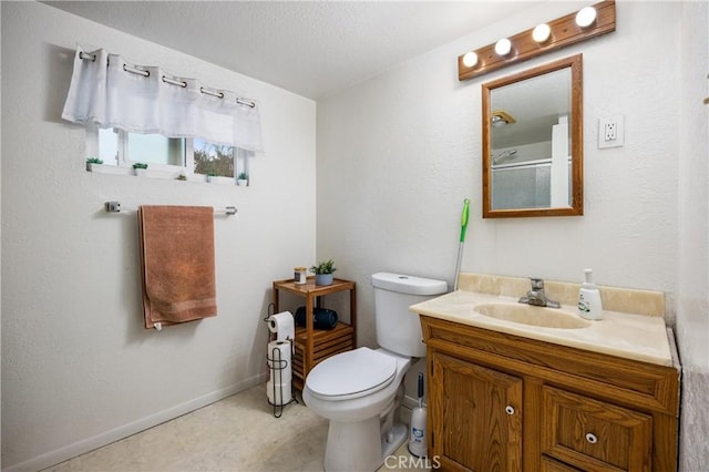 bathroom featuring toilet, walk in shower, and vanity