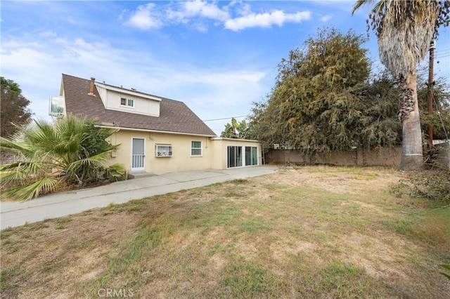 back of house with a patio area and a yard