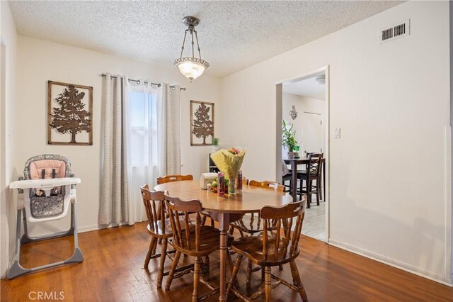 dining room featuring hardwood / wood-style floors and a textured ceiling