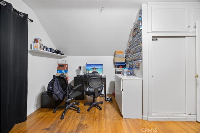 office space with vaulted ceiling and light hardwood / wood-style flooring