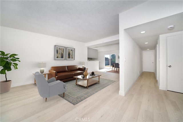 living room featuring a textured ceiling and light hardwood / wood-style floors