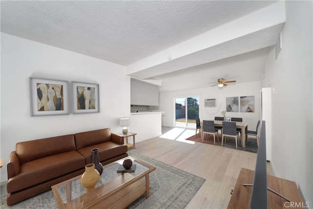 living room with a wall unit AC, ceiling fan, a textured ceiling, and light wood-type flooring