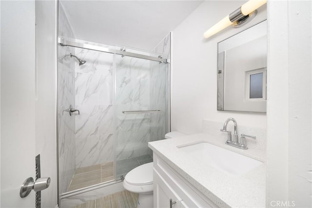 bathroom with toilet, an enclosed shower, and vanity