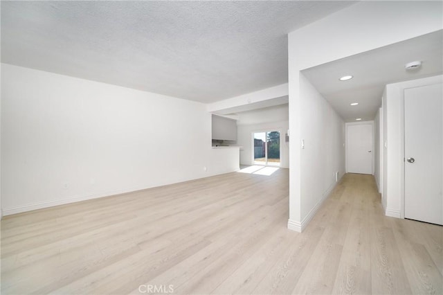 interior space featuring light wood-type flooring and a textured ceiling