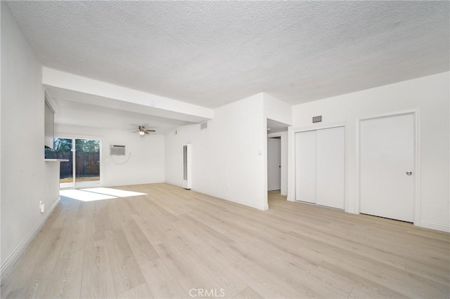 unfurnished living room with a textured ceiling, ceiling fan, and light hardwood / wood-style flooring