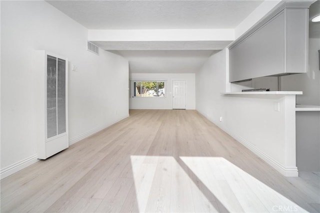 unfurnished living room featuring light hardwood / wood-style flooring and vaulted ceiling