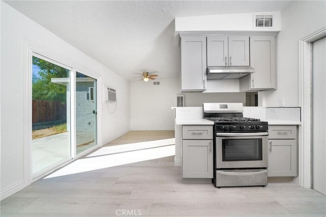 kitchen with ceiling fan, light hardwood / wood-style floors, stainless steel gas range, and gray cabinetry