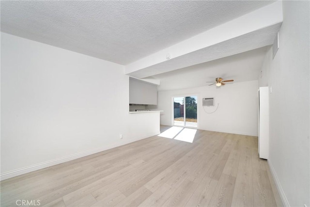 unfurnished living room with a textured ceiling, ceiling fan, a wall mounted AC, and light wood-type flooring