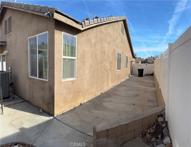 view of side of home featuring a patio area and central air condition unit