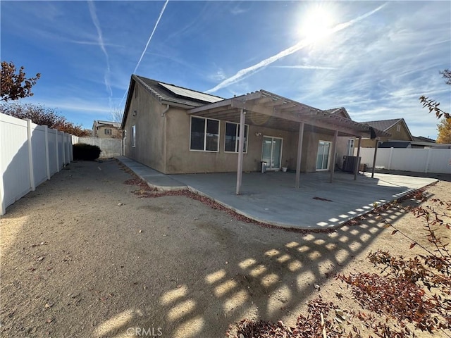 rear view of property with cooling unit and a patio